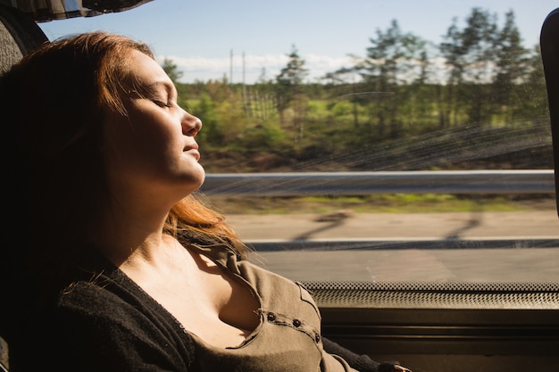 Mulher viajante dormindo em uma viagem de trem ao lado da janela