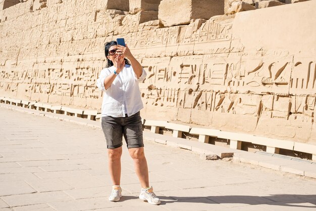 Foto mulher viajante explora as ruínas do antigo templo de karnak, na cidade de luxor, no egito