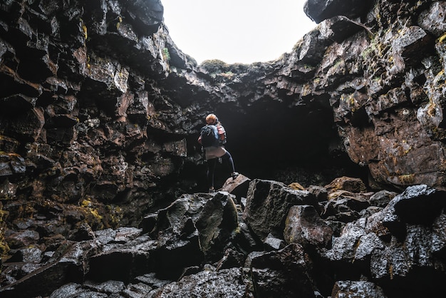 Mulher viajante explorar o túnel de lava na Islândia.