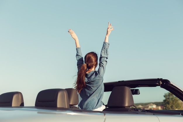 Mulher viajante feliz em carro cabrio