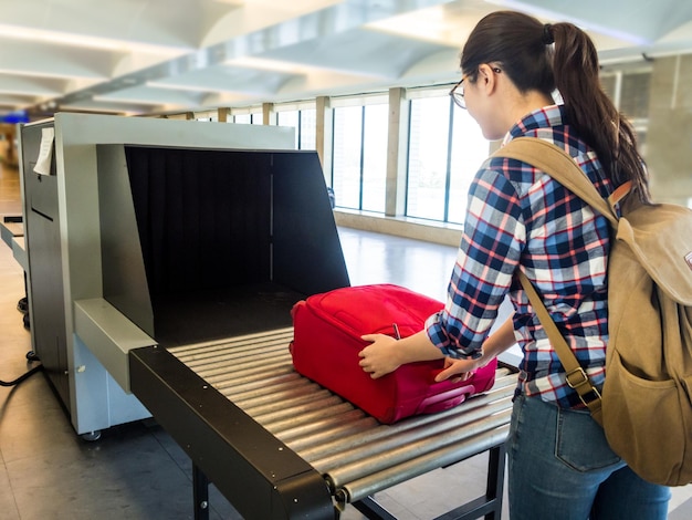 mulher viajante foco seletivo Bagagem máquina de raio-x tentar detecção metal prevenção mau terrorista para atacar o avião no aeroporto antes de decolar.