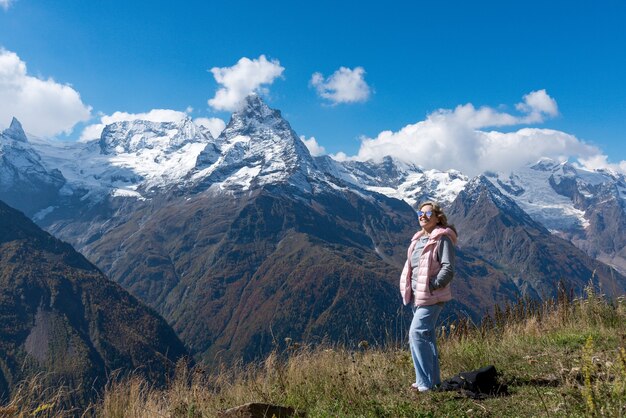 Mulher viajante toma café com vista para a paisagem montanhosa