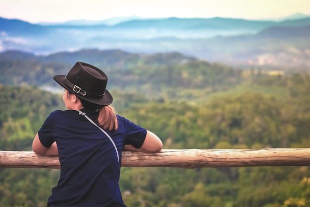 Mulher viajante vê vista nevoeiro na montanha