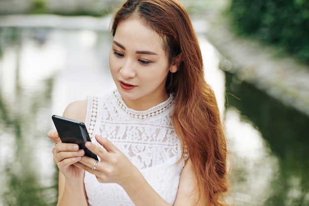 Mulher vietnamita lendo mensagem de texto