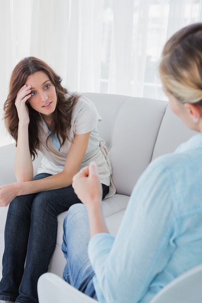 Mulher virada sentada com o terapeuta falando com ela