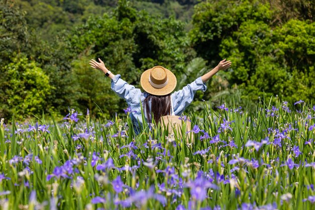 Mulher visita o jardim de flores com iris tectorum