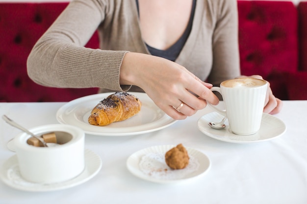 Mulher, xícara café, cappuccino, croissant, café manhã