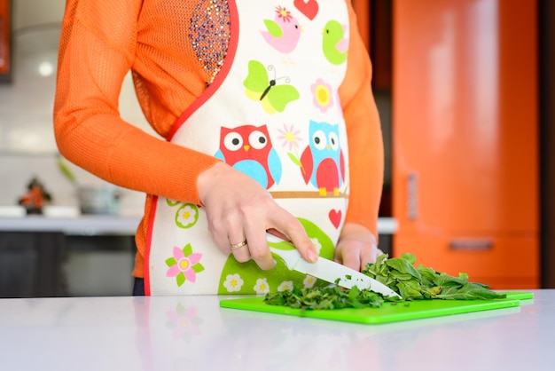 Mulher Yang cortando salada na cozinha