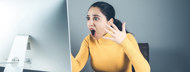 Mulher zangada com computador no escritório