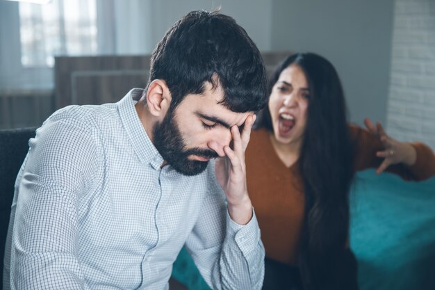 Mulher zangada e homem triste na sala