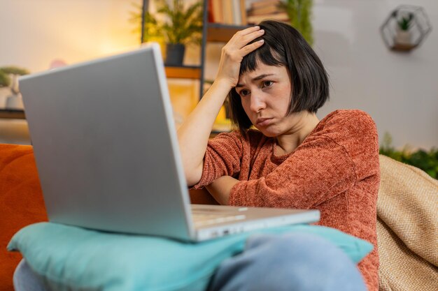 Mulher zangada usando laptop trabalhando perde ficando surpreso resultados repentinos da loteria más notícias perda falhar