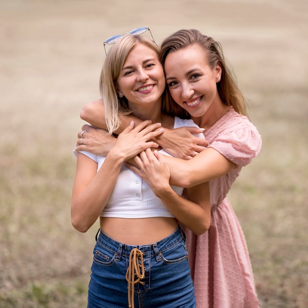 Foto mulheres abraçando a amiga por trás