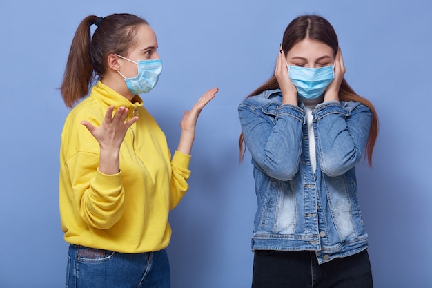 Mulheres adolescentes com máscara cirúrgica para prevenção de coronavírus