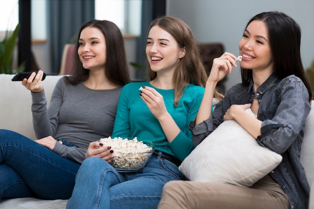 Mulheres adultas positivas que olham séries junto