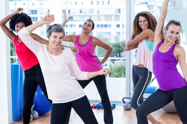 Mulheres alegres exercitando com braços levantados