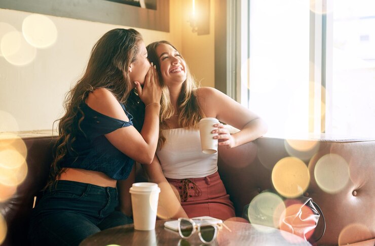 Foto mulheres amigas e se unindo com fofocas rindo ou em segredo em café para férias de fim de semana ou viagem mulheres juntas e conversando em restaurante ou café bokeh para relaxar conversa ou diversão