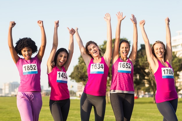 Mulheres animadoras que apoiam a maratona do câncer de mama