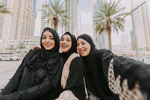 Mulheres árabes com abaya se unindo e se divertindo ao ar livre Feliz encontro de amigos do Oriente Médio