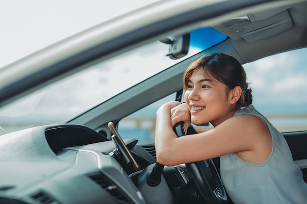 Mulheres asiáticas atraentes sorrindo e olhando diretamente enquanto dirigia um carro. viajar férias Conceito de relaxamento e aproveitamento.