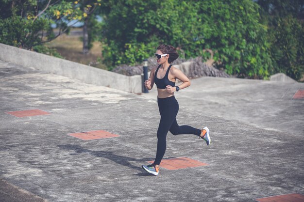 Mulheres asiáticas, correr e correr durante ao ar livre na cidade correr