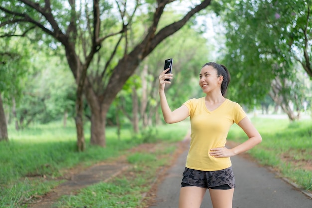 Mulheres asiáticas estão ouvindo música e correndo no parque.