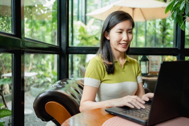 Mulheres asiáticas estão usando seus laptops para trabalhar no café