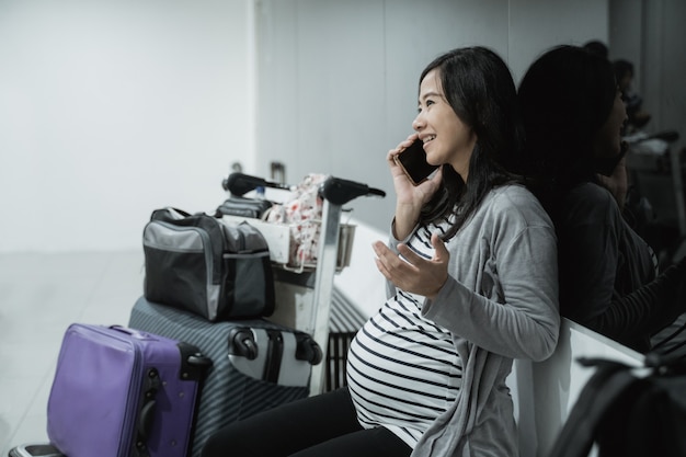 Foto mulheres asiáticas grávidas usam smartphones para ligar