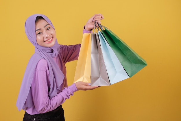 Mulheres asiáticas lindas e felizes com compras compulsivas segurando sacolas de compras