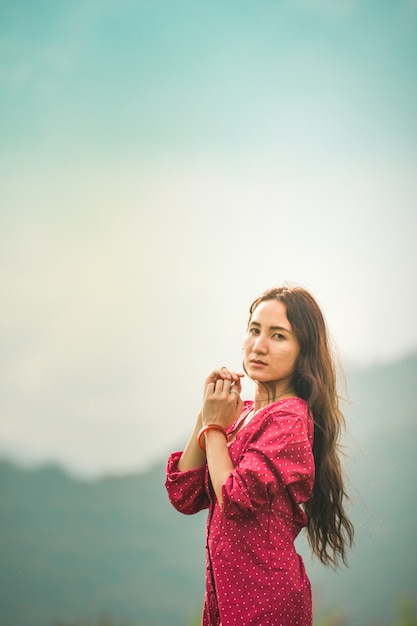 Mulheres asiáticas no vestido vermelho no nascer do sol