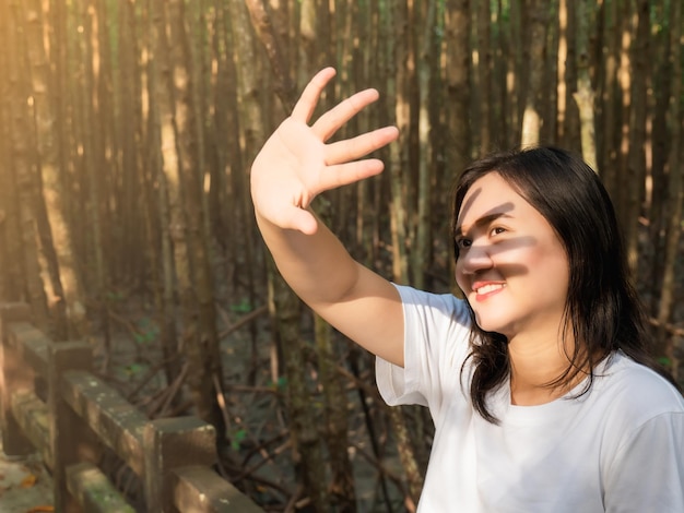 Foto mulheres asiáticas sorridente colocam as mãos juntas para bloquear a luz do sol em seus olhos enquanto tiram fotos