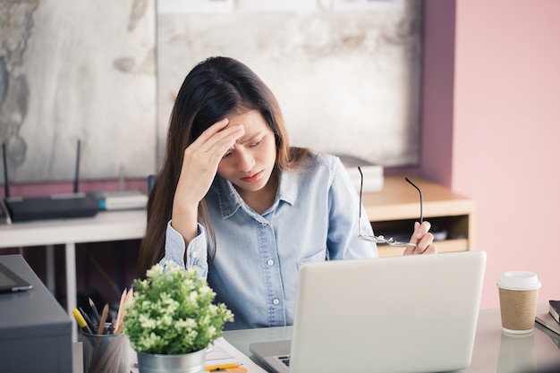 Mulheres asiáticas Stressful Trabalhando com um notebook por um longo tempo, conceito de síndrome do escritório