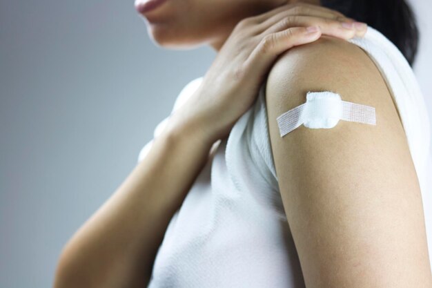 Mulheres asiáticas têm gesso no ombro depois de dar uma injeção de vacina