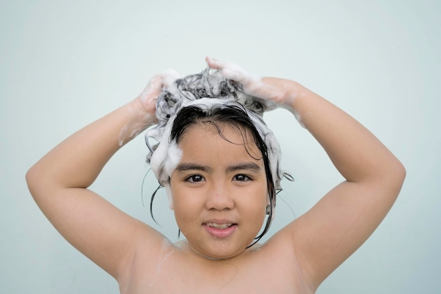 Mulheres asiáticas tomando banho e ela estava tomando banho e lavando cabeloela está feliz Na cabeça dela um xampu espumante branco