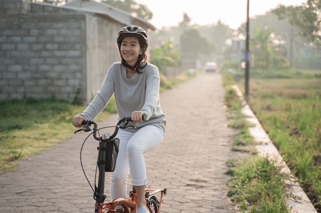 Mulheres asiáticas usam capacetes para andar de bicicleta dobrável