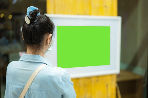 Mulheres asiáticas usando máscaras viram as costas veja as fotos na exposição a imagem foi cortada em uma cena verde