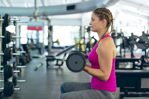 Foto mulheres atletas se exercitando com halteres em um centro de fitness