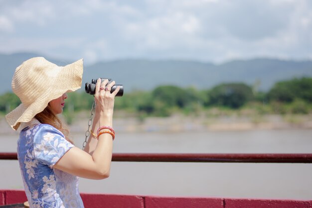 Mulheres bonitas assistem ao rio Mekong entre a Tailândia e o Laos PDR.