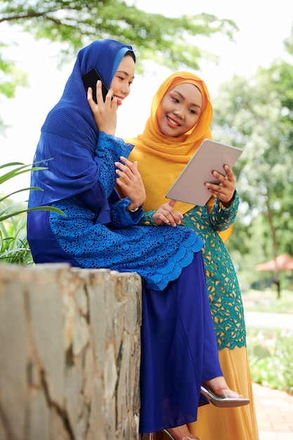 Mulheres bonitas em hijabs com dispositivos