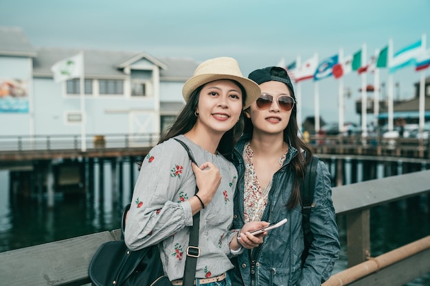 mulheres bonitas em pé no cais e uma mostrando um lindo sorriso para a câmera.