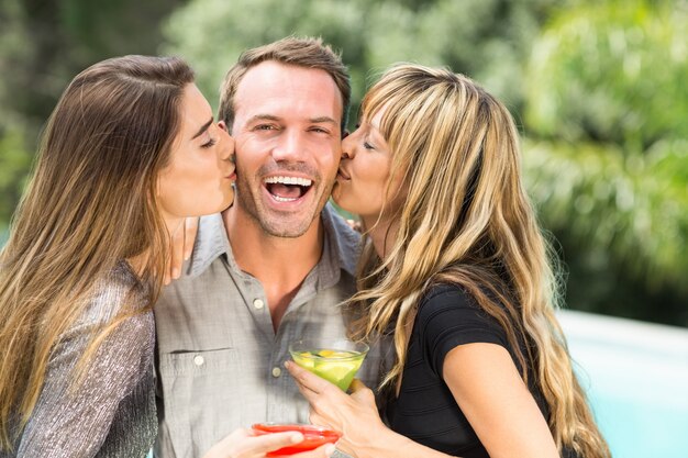 Mulheres bonitas que beijam o homem feliz