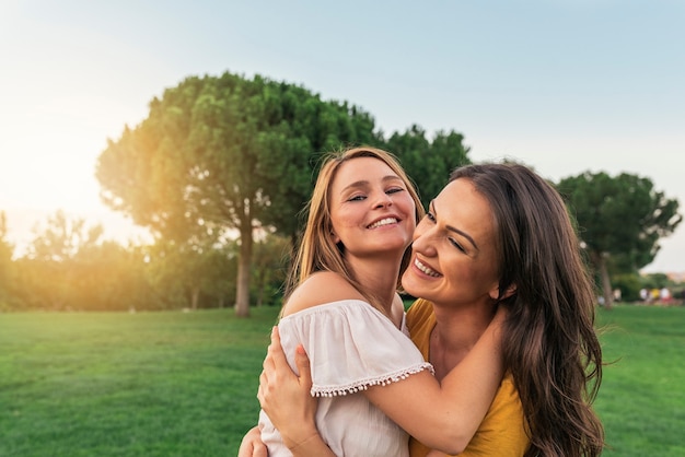 Mulheres bonitas sorrindo e se divertindo no parque. amigos e o conceito de verão.