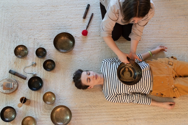 Foto mulheres brancas usam taças cantantes para massagem, terapia de som, terapia de som, conceito de medicina alternativa