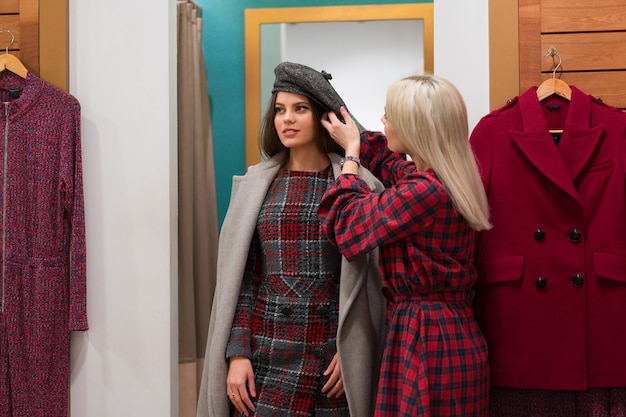 Foto mulheres caucasianas em uma boutique de moda escolhem vestido