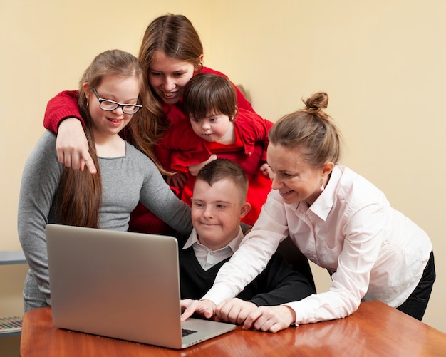 Foto mulheres com crianças com síndrome de down no laptop