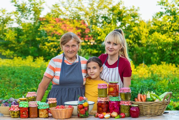 Mulheres com legumes preservados em jarra para a mãe e filha de inverno Foco seletivo