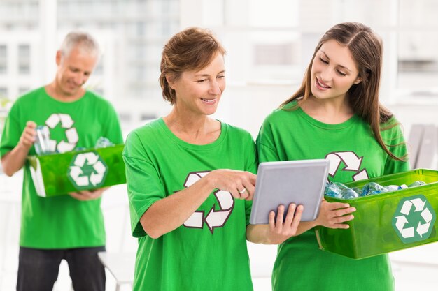 Foto mulheres com mentalidade ecológica com tableta e caixa de reciclagem