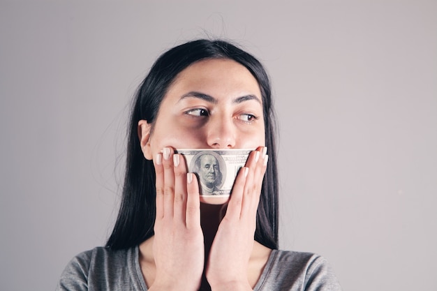 Mulheres com uma nota de um dólar na boca