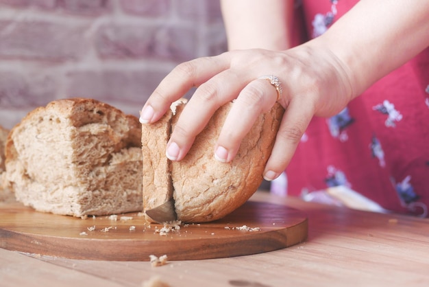 Mulheres cortando pão de sobrancelha assado na mesa