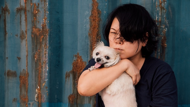 Mulheres da Ásia e cão feliz abraçando com recipiente