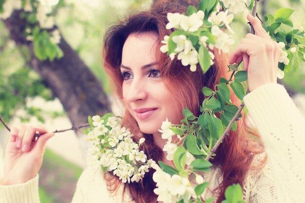 Mulheres de cabelo ruivo no ramo de flores de maçã